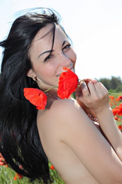 Черноволосая красотка играется с цветами 