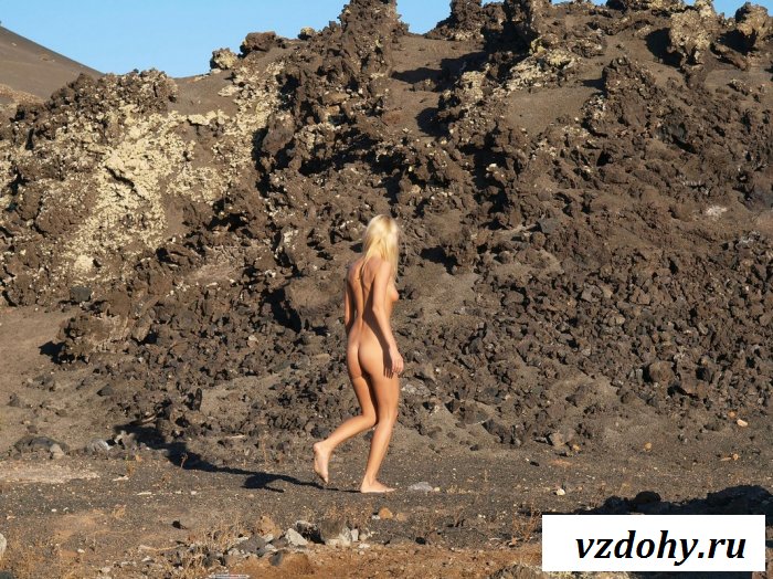 Смуглая блонда на фоне скал.