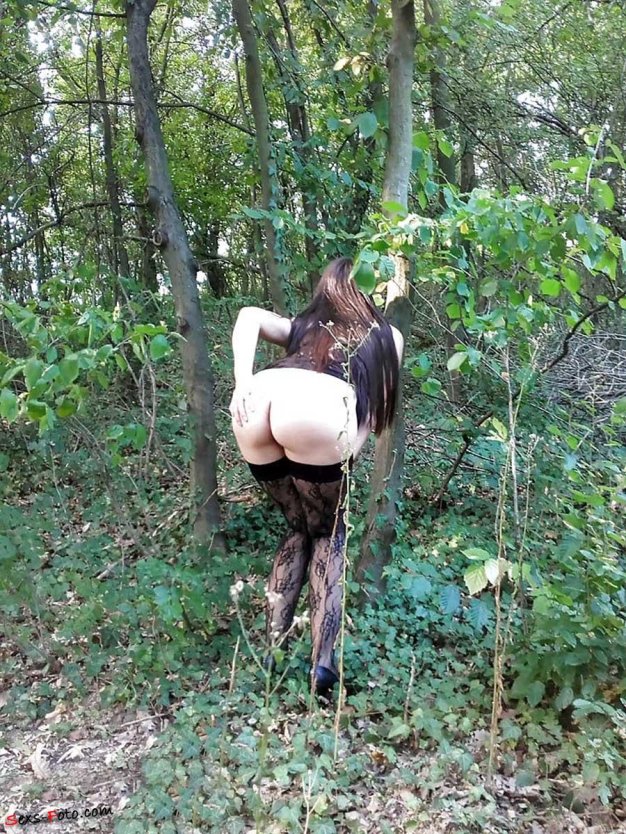 Женщина нагнулась в лесу